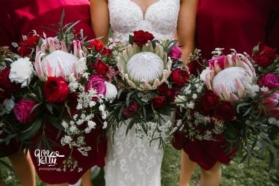 Protea wedding bouquet, roses with mix of seasonal flowers in ruby tones