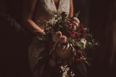 King Protea bouquet with roses and other burgundy/blush toned flowers.
