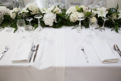 bridal table with white and green blooms and hire tables and tablecloths
