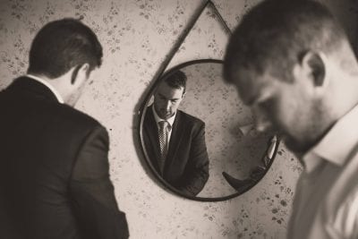 groom getting ready in front of mirror