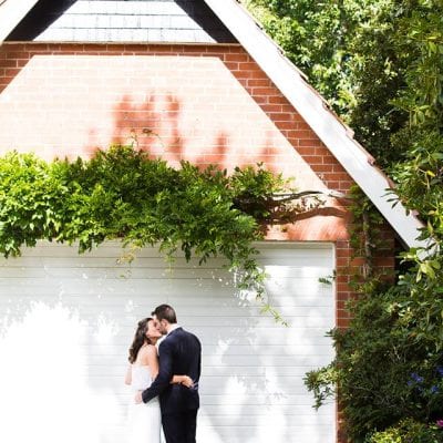 red brick garage with wisteria and bride and groom