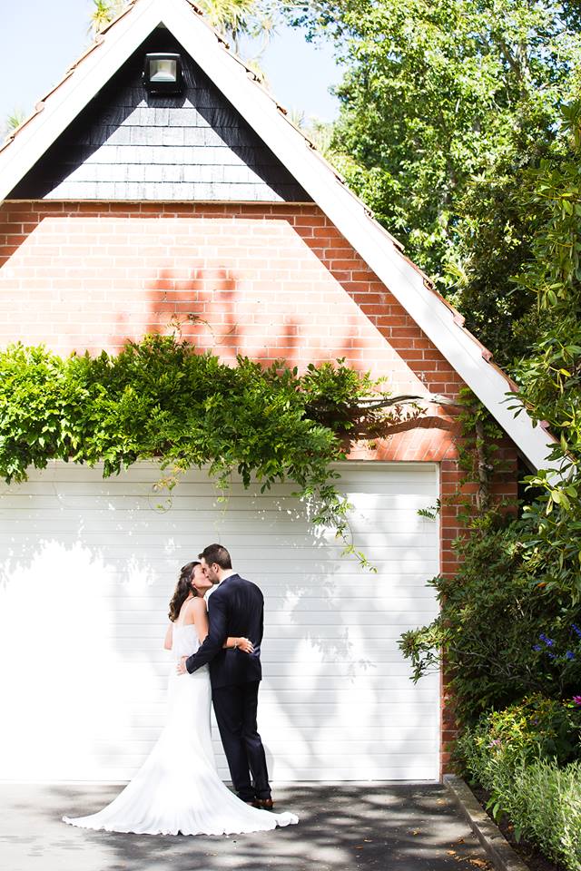 red brick garage with wisteria and bride and groom