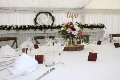 geometric vase filled with burgundy and blush blooms